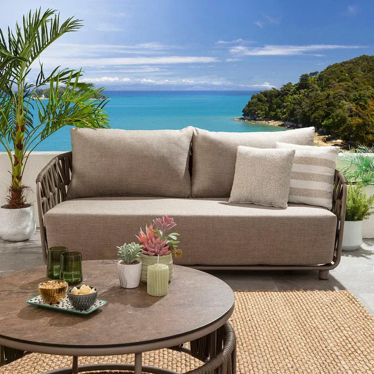 Round Solara coffee table positioned in front of the outdoor sofa